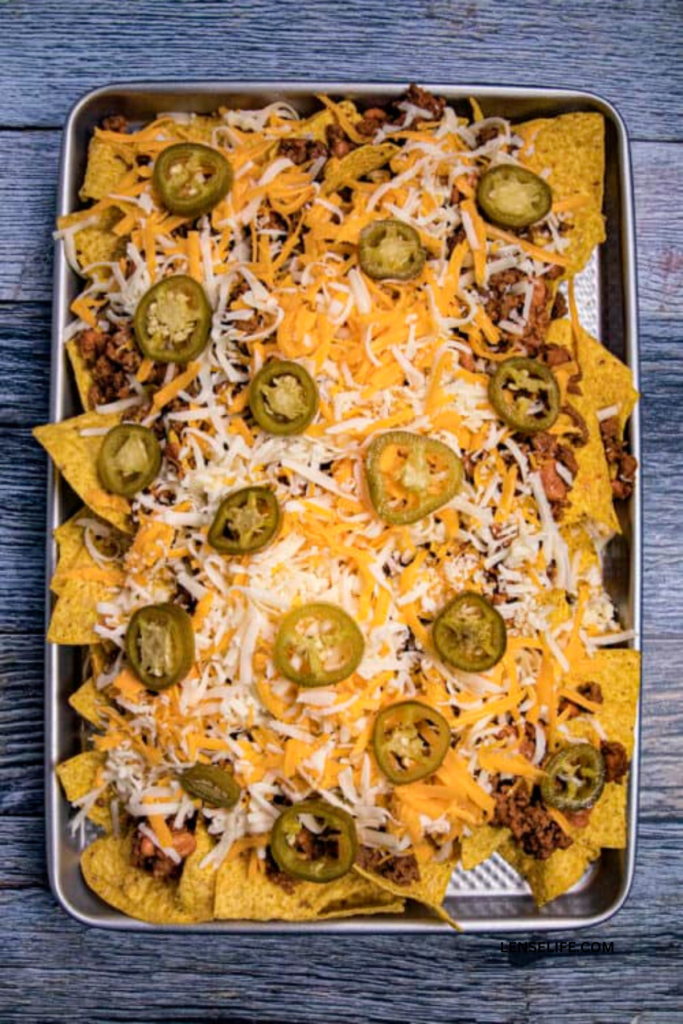 Assembled nachos with toppings ready to bake