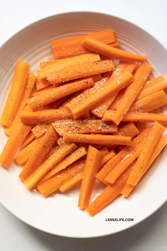 seasoning the carrots in a bowl