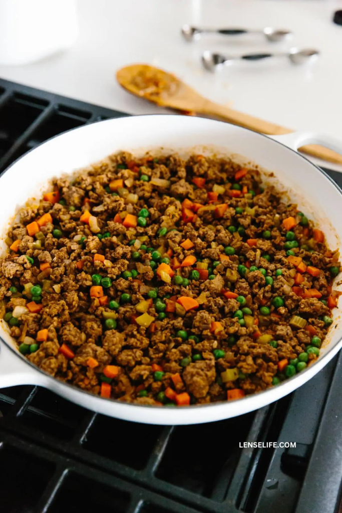 combining meat with veggies in a pan