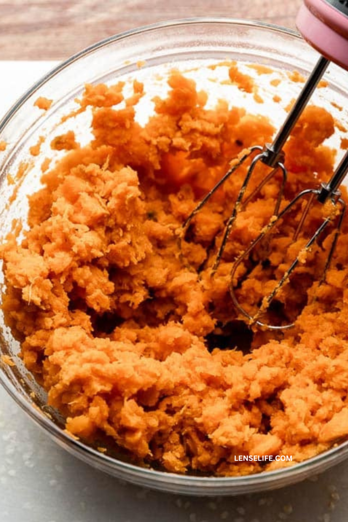 mashing the sweet potatoes in a bowl